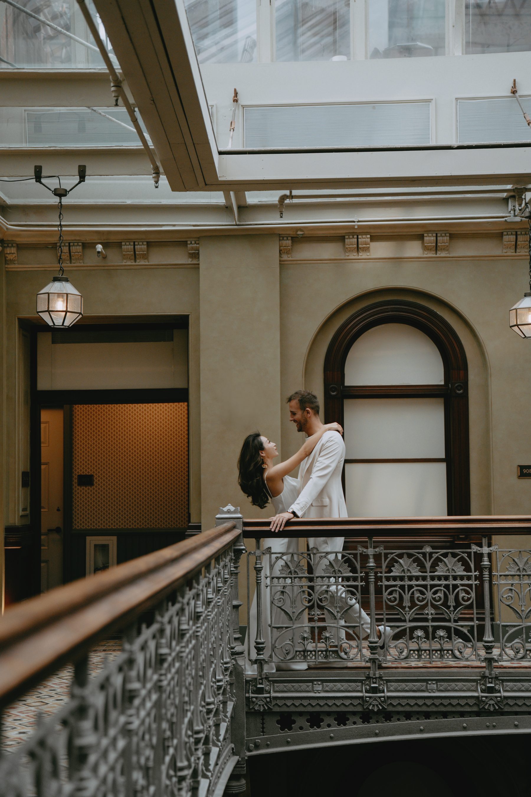 Brandon and Kayla on a balcony in a sunlit atrium