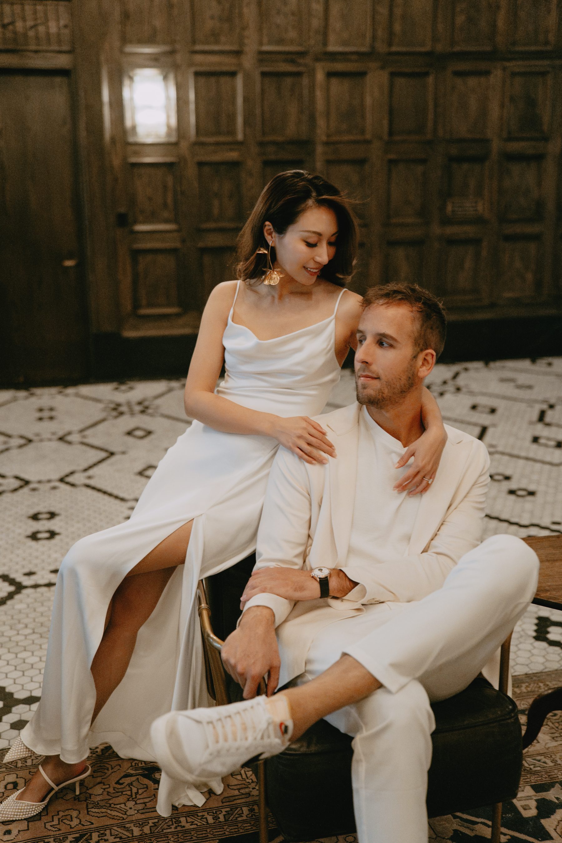 Brandon and Kayla walking beneath a grand chandelier