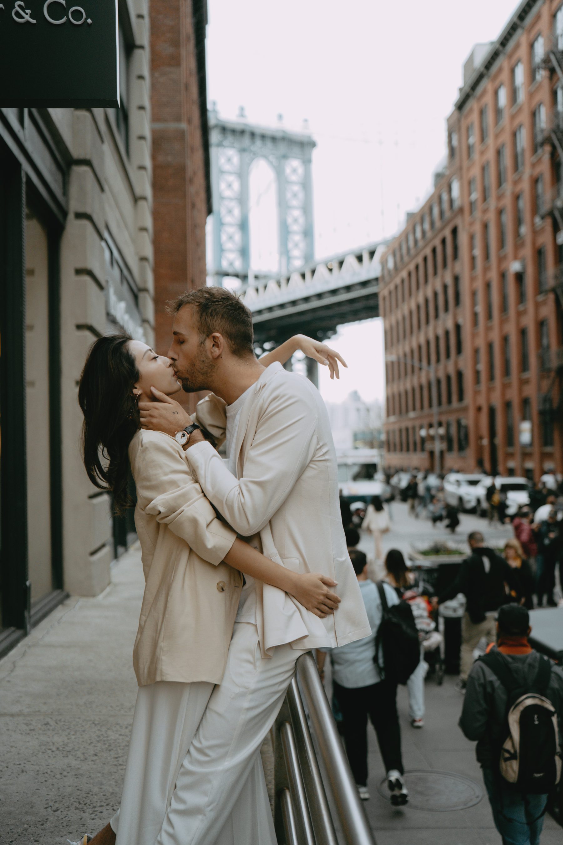 Brandon and Kayla kissing beneath the Manhattan Bridge
