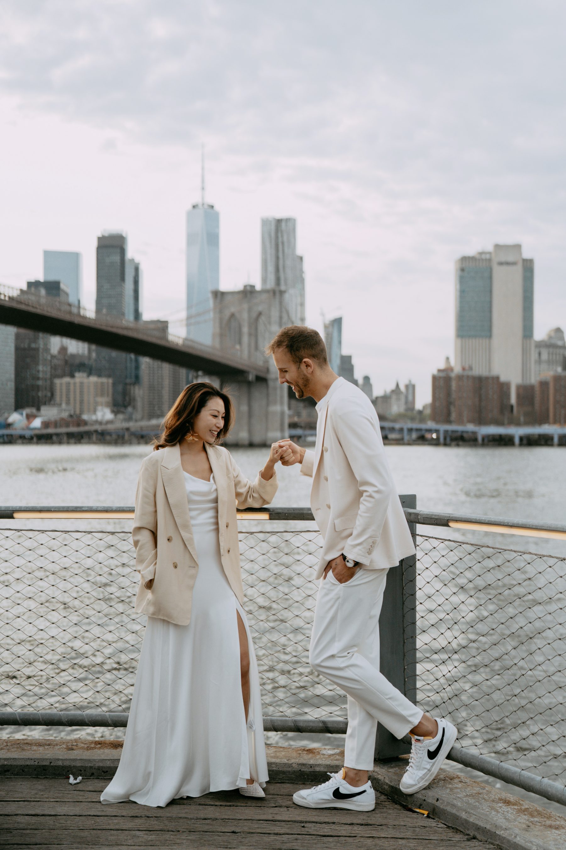 Brandon kissing Kayla's hand on the waterfront with the skyline behind