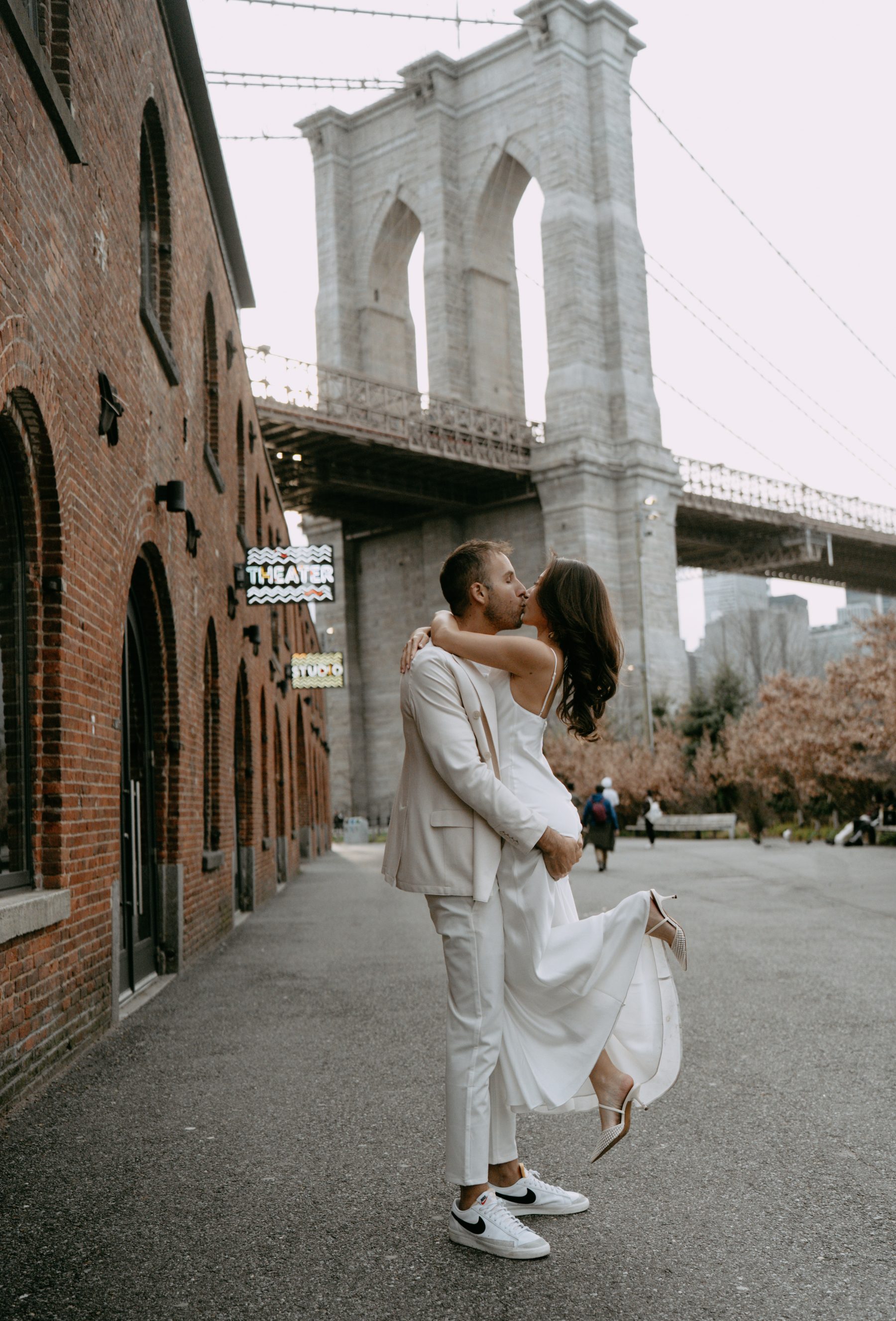 Brandon lifting Kayla beneath the Brooklyn Bridge